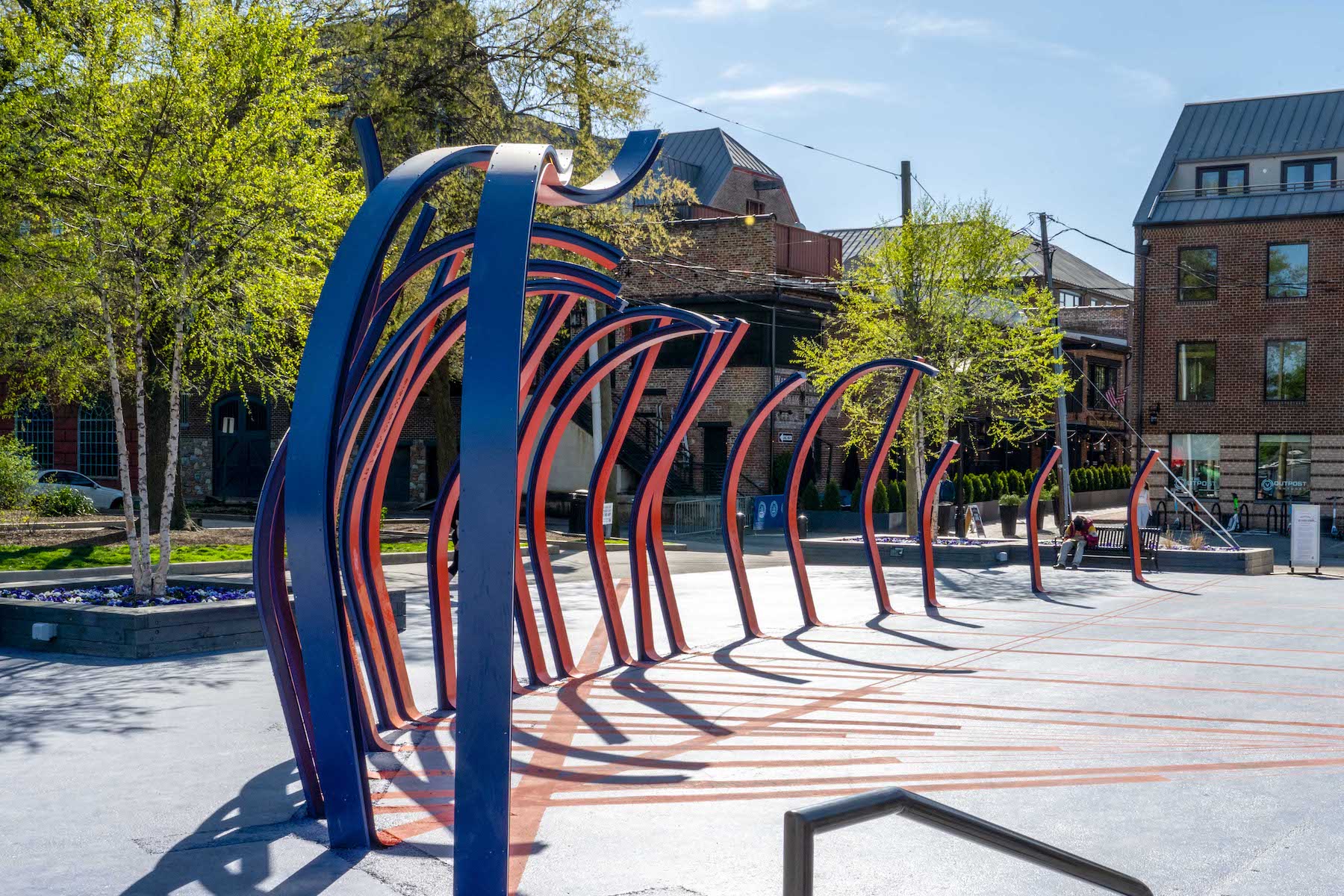 A few blue and red curved sculptures placed beside on another outside.