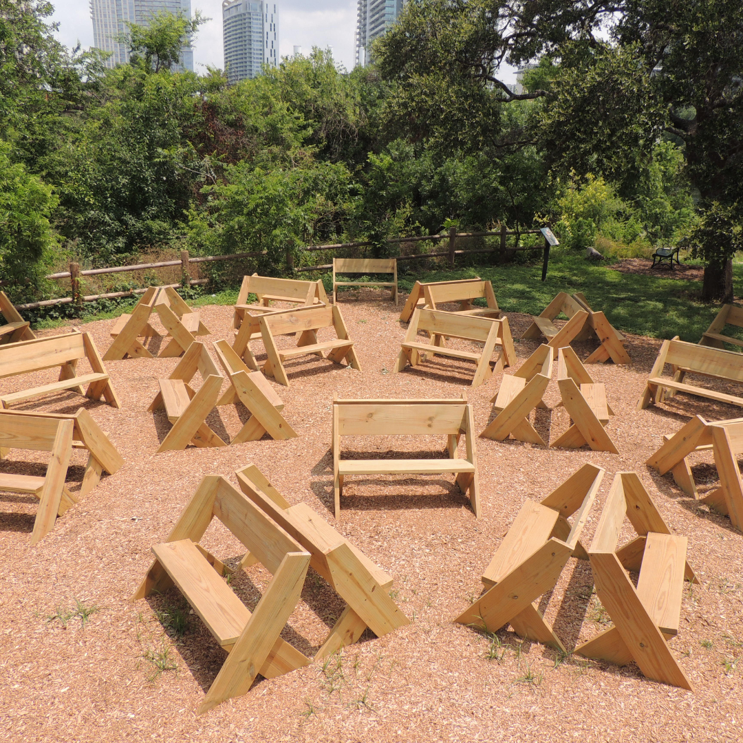 Several artworks made out of wood placed outside in a park.