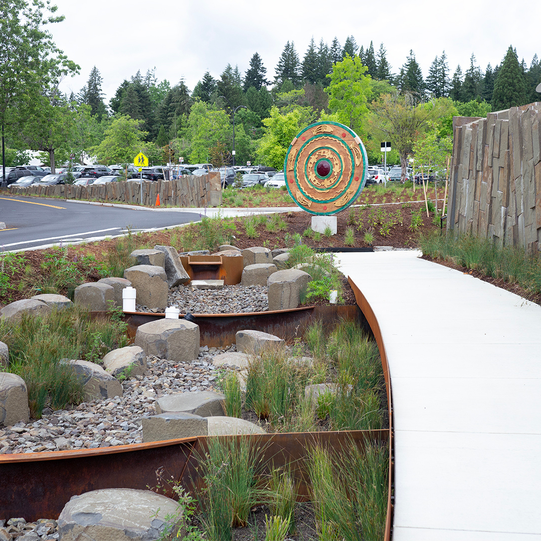 A colorful wheel placed outside in a garden.